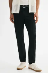 Pantalón slim fit negro de sarga de algodón, de corte ajustado, con cinco bolsillos y cierre frontal con botón y cremallera.
