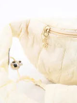 Riñonera acolchada celeste con correa ajustable y cierre superior con dije de flor.