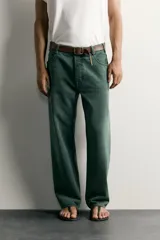 Jeans relaxed fit de algodón color verde oscuro, de tiro medio y pernera recta con raya de planchado. Cuenta con diseño de cinco bolsillos y cierre frontal con cremallera y botón.