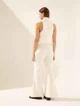 Pantalón Oxford color blanco con apliques bordados en hilo y piedras brillantes en la parte inferior de la bota.