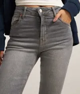 Pantalón skinny de cintura alta confeccionado en denim negro con elastano, con cierre de botón y cremallera, trabillas para cinturón y bolsillos funcionales en la parte delantera y trasera.