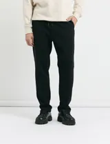 Pantalón jogging de corte recto, confeccionado en tejido circular con cintura elástica y cordón ajustable al tono. Presenta bolsillos laterales tipo parche.