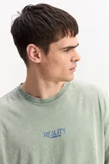 Remera oversize de algodón con efecto acid wash y diseño boxy, de mangas corta con estampa frontal pequeña y sutil.