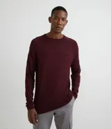 Suéter de punto color borgoña con cuello redondo y manga larga raglán. Presenta rayas horizontales texturizadas.