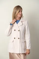 Blazer verde con corte clásico, doble botonadura y bolsillos con solapa.