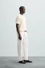 Camiseta negra de punto perlado, corte regular fit, cuello redondo, manga corta y rib en los acabados.