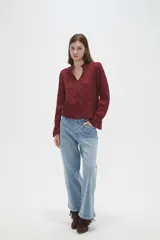 Blusa de viscosa color bordó con diseño bordado geométrico, cuello en V y mangas largas con terminación en volados.