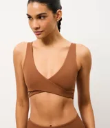 Top deportivo Get Over color marrón, confeccionado en microfibra, con diseño cruzado en el frente y escote en V profundo.