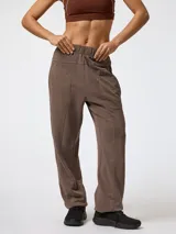 Pantalón jogger color marrón, de corte holgado, con cintura elástica y costuras decorativas frontales.