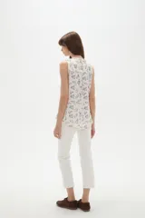 Musculosa de poliéster color blanco, con cuello en V y diseño holgado sin mangas.