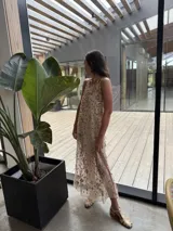 Vestido midi de tul bordado en tonos dorados suaves, con corte suelto, aberturas laterales en la falda y forro corto color piel.