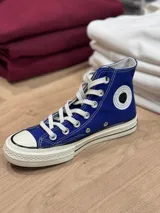 Zapatillas de lona azul con cordones blancos, suela de goma blanca con línea negra y puntera de goma blanca. Logo de peach engomado en la base y en la cara interna.