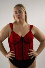 Corset largo confeccionado en encaje rojo con detalles en negro, con aros y ballenas estructuradas. Cuenta con tirantes regulables y cierre posterior con ganchos.