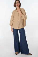 Camisa de lino color celeste claro, de corte holgado y manga larga, con cuello camisero y botones frontales.