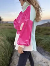 Polerón de corte holgado con mangas largas abullonadas, confeccionado en terciopelo negro con detalles en beige y blanco.