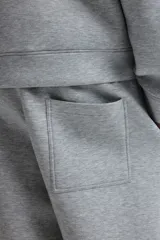 Pantalón tipo jogger de corte relajado con efecto neopreno, cintura elástica con cordón ajustable, bolsillos laterales al bies y bolsillo trasero de parche.