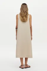 Vestido midi color crudo de corte relajado, con caída fluida, sin mangas y escote en V.