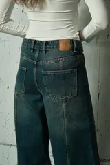 Jean de corte wide leg en color azul oscuro, con costuras verticales decorativas en el frente y diseño de tiro medio.