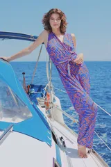 Mono largo de viscosa con estampado abstracto en tonos azules y naranjas, escote en V cruzado y lazo ajustable en la cintura.