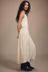 Vestido largo de cuello halter con diseño plisado y textura arrugada. Presenta espalda descubierta con cierre de lazo y cintura elástica.