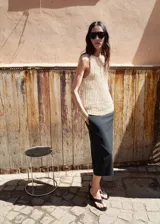 Top tejido de punto grueso en color beige, con cuello redondo y diseño sin mangas con tirantes anchos.