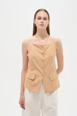Top de viscosa color blanco con tirantes finos, cuello a la base y cierre frontal con botones. Presenta bolsillos appliqués con solapa en la parte inferior y diseño al cuerpo.