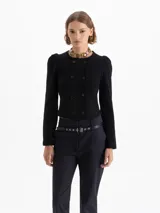 Saco tipo cardigan corto de tejido de punto, con cuello redondo, mangas largas con hombros ligeramente abullonados y cierre frontal cruzado con botones.