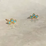 Par de aros dorados con tres piedras turquesas.