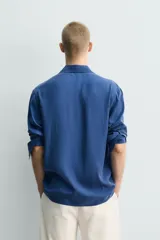 Camisa de corte relajado confeccionada en tejido fluido con mezcla de cupro, de manga larga con puños abotonados y cierre frontal de botones.