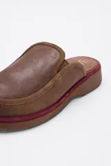 Zuecos de cuero vacuno en color beige, con diseño de punta redondeada y suela plana de goma.