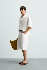 Camisa de corte relajado confeccionada en tejido mezcla de lyocell, con cuello solapa, manga corta y cierre frontal con botonadura oculta.