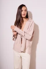 Blusa color visón con escote en V profundo y lazos ajustables en el frente, mangas largas y corte holgado.