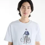 Remera New Balance de jersey de algodón color gris melange, de manga corta y cuello redondo, con diseño gráfico estampado en el pecho que muestra a una persona con bicicleta.