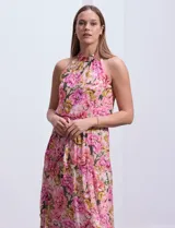 Vestido largo de gasa estampada con flores rosas, amarillas y verdes, marca Julia Jordan. Tiene escote halter, cintura elastizada con lazo de ajuste, abertura en la espalda con botones y forro interno a tono.