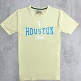 Remera amarilla de algodón con estampa azul de la palabra "Houston" y el número 1982.
