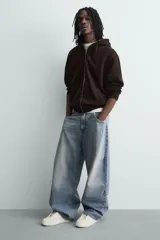 Zapatilla negra de cordones, con parte superior lisa y cordonera oculta. Posee suela con volumen a tono.