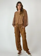 Pantalón cargo color marrón de seda con bolsillos laterales con solapa, cintura elastizada con cordón ajustable y corte holgado.