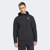 Campera deportiva Adidas del Real Madrid, color negro, con cierre frontal, capucha y corte entallado. Presenta el logo de Adidas y el escudo del club en tono sobre tono en el pecho.
