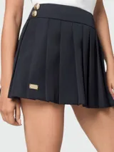 Falda corta plisada de lana color negro, con diseño estilo marinero y detalle de placa metálica dorada en la parte inferior.