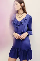 Vestido corto azul de viscosa con cuello en V, volados en el escote, mangas largas con puños fruncidos y falda con volado en el ruedo. Incluye un lazo para ajustar en la cintura.