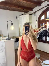 Body de encaje color rojo con escote pronunciado, breteles regulables y diseño tipo tanga en la parte inferior.