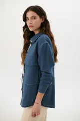 Sobrecamisa azul con cuello clásico, cierre frontal con botones y bolsillos de parche en el pecho.