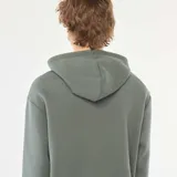 Buzo con capucha de corte holgado, color verde militar, con bolsillo frontal tipo canguro y cordones ajustables en el cuello.