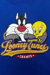 Buzo azul de cuello redondo con estampa frontal vintage de Silvestre y Piolín junto al logo de Looney Tunes Champs.