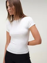 Remera blanca de manga corta y cuello redondo, confeccionada en tejido rib texturizado con corte entallado al cuerpo.