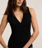 Blusa estilo chaleco, confeccionada en ribana negra, con abotonado delantero, sin mangas y con textura acanalada.