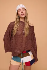 Sweater verde oliva de lino tejido a mano con diseño de trenzas. Tiene silueta oversize, mangas rectas y cuello redondo.