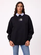 Sweater negro de corte holgado con estampado trasero de flores y el logo "Rusty" en colores neón.