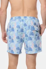 Short de baño celeste con estampado tropical de hojas en tonos azules y rosados, con cintura elastizada y cordón ajustable.