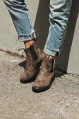 Botas de cuero marrón con elásticos laterales negros, suela negra y tirador trasero.